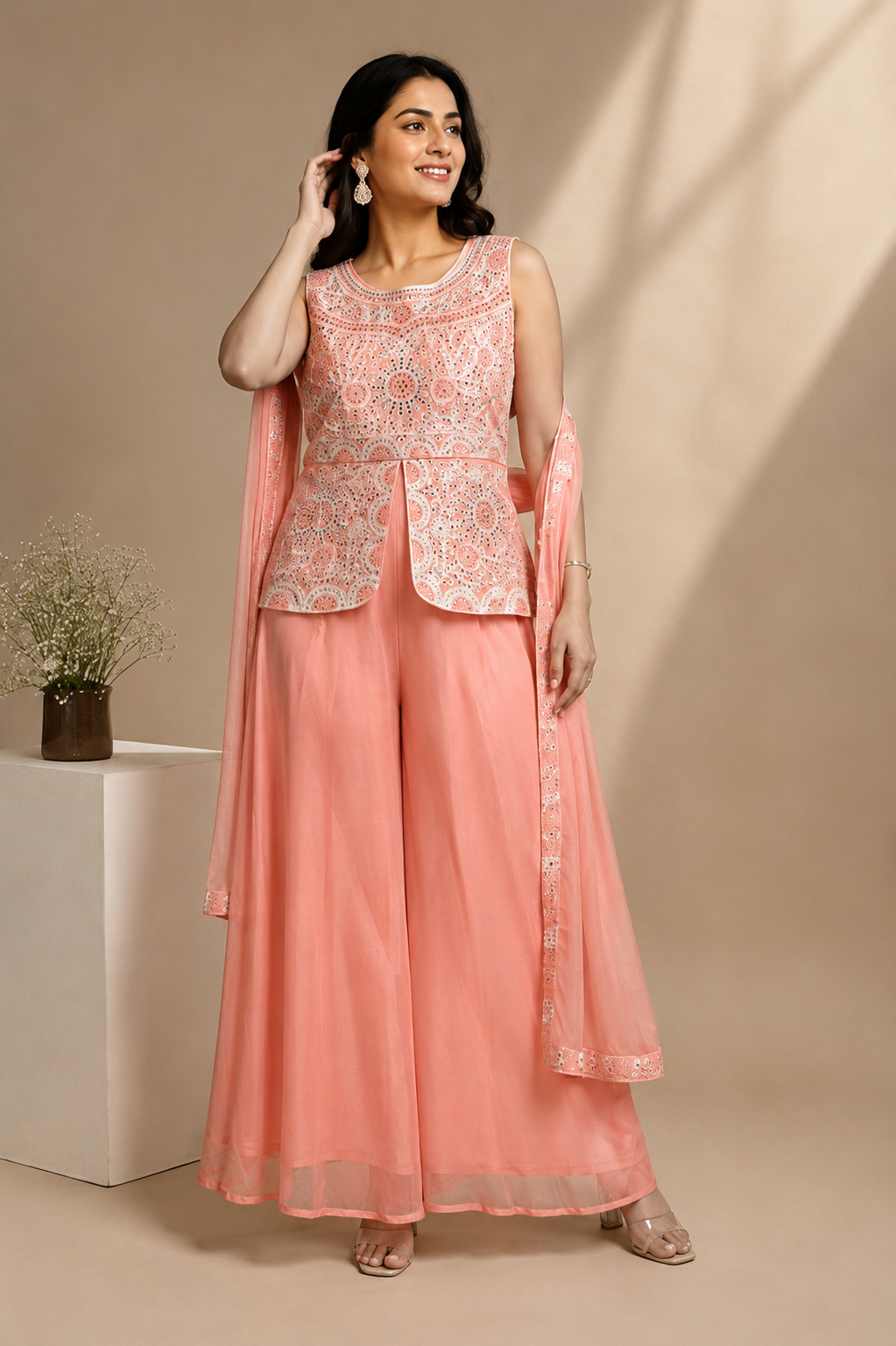 Peach embroidered 3-piece ethnic suit set with sleeveless embellished top, palazzo pants and dupatta on model