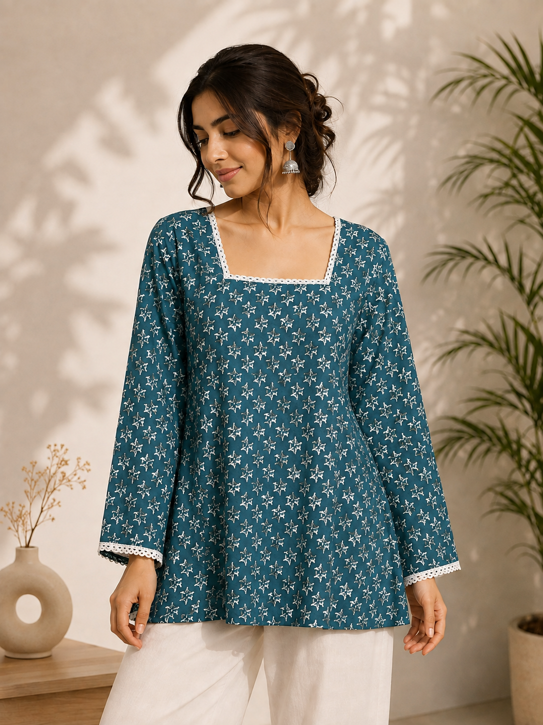 Women wearing a teal floral printed kurta with lace-up back detailing in a professional studio setting